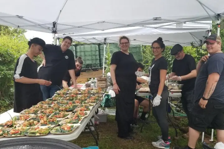 a group of people standing around a table