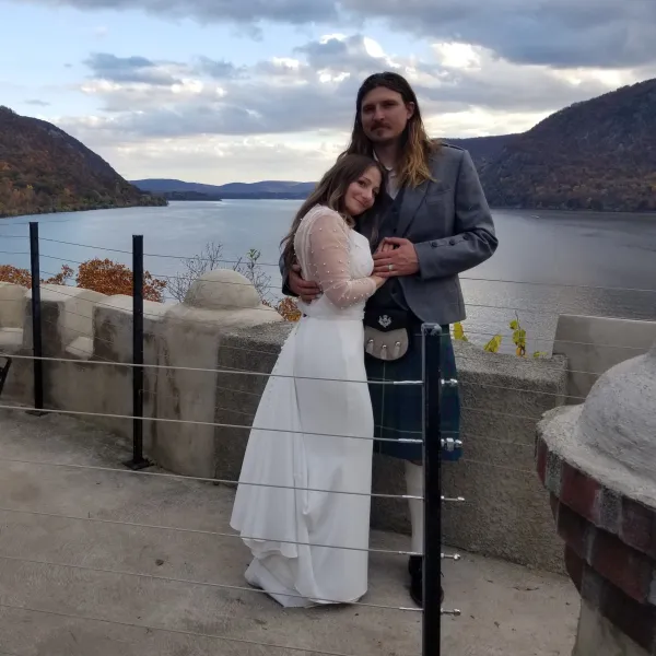 a woman standing in front of a body of water posing for the camera