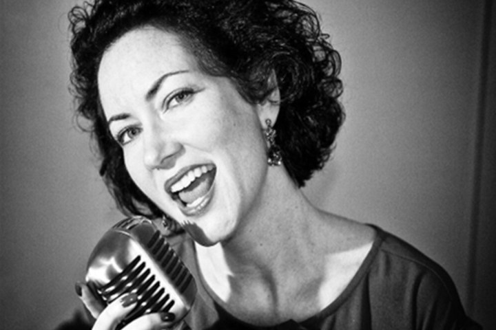 a person holding a microphone posing for the camera