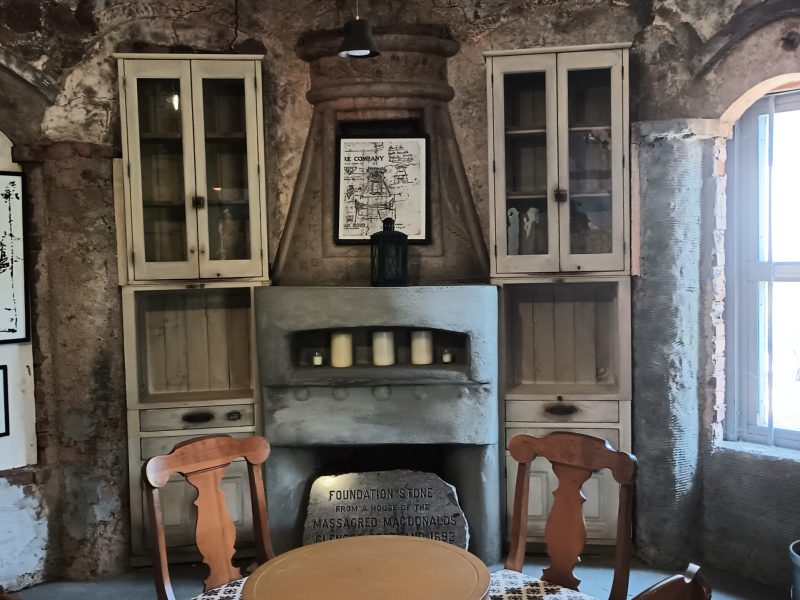 a fire place sitting in a chair next to a fireplace