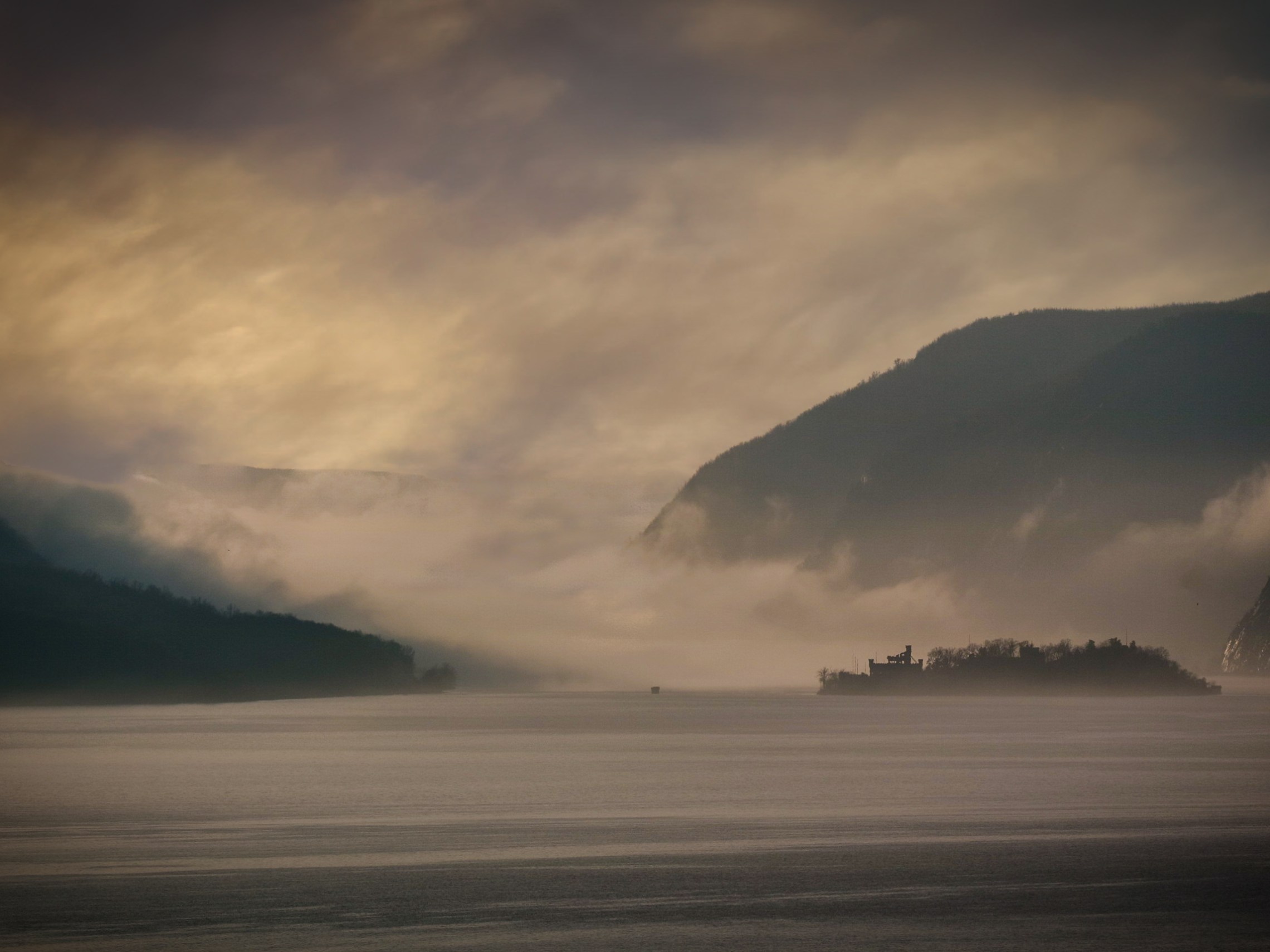 a large body of water with a mountain in the background