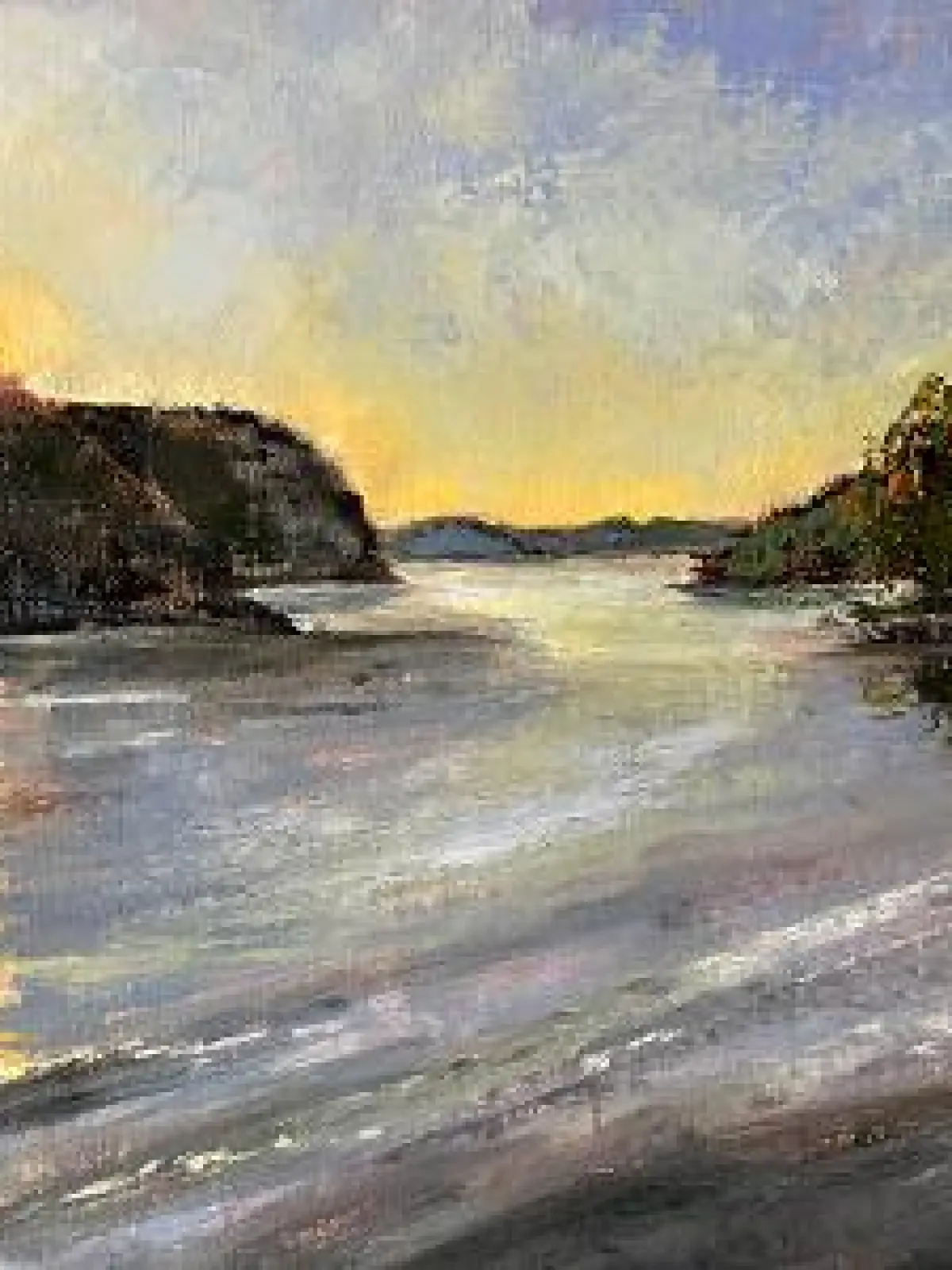 Sunset over a lake with hilly shores and colorful reflection on the water.