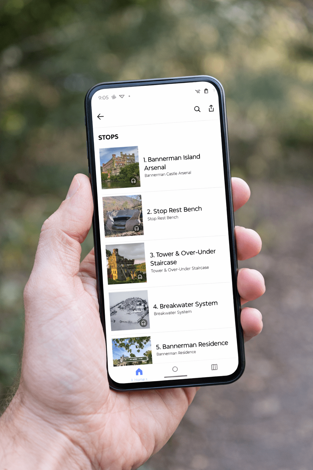 Hand holding smartphone displaying a list of locations with images.